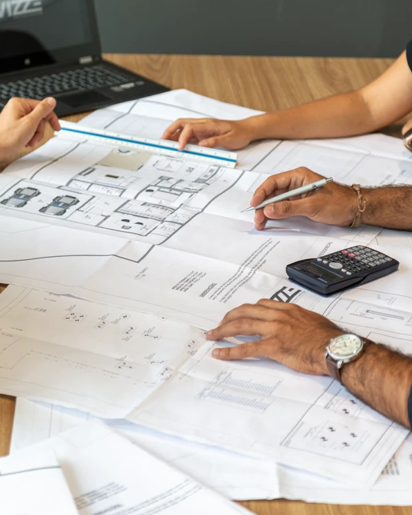 Tauranga home owners and Home Improvement Specialist team gather around house plans on table
