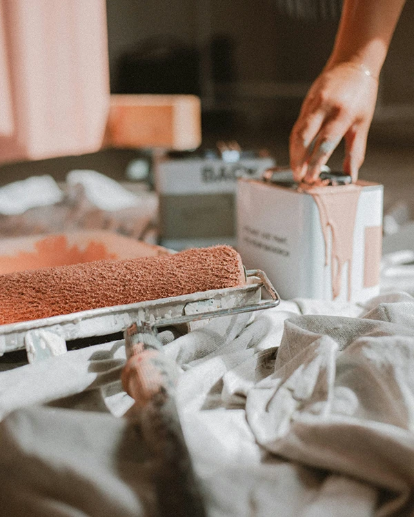 Close up of a paint roller covered in peach coloured paint during home painting in Tauranga home.