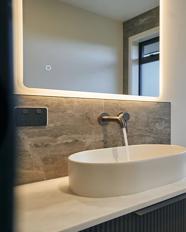 A running tap pouring water into a bathroom vanity.